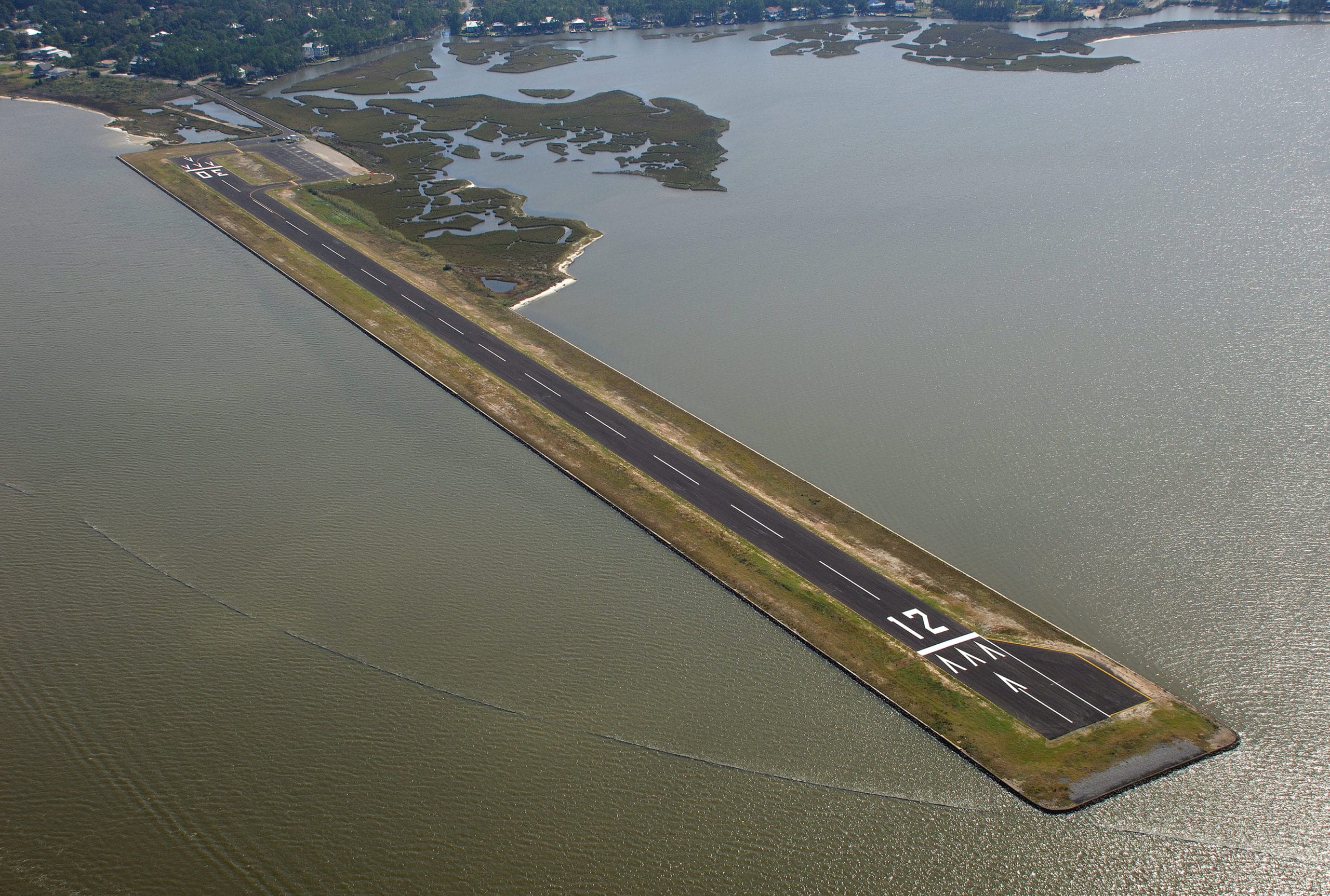 Aerial overview of Jeremiah Denton Airport and its waterfront perimeter on Dauphin Island